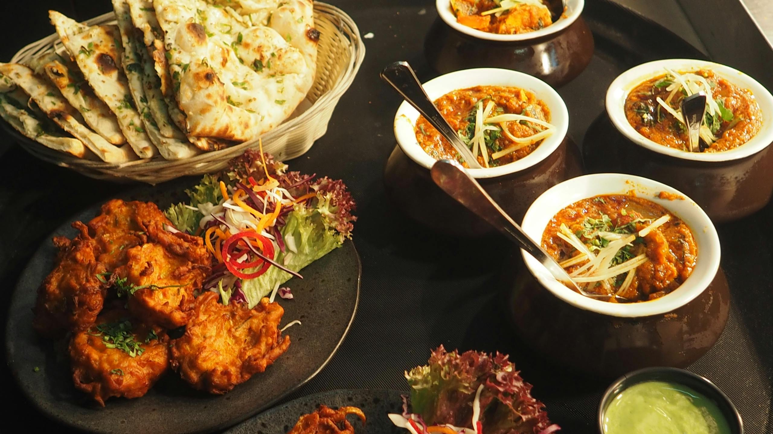 Prototipo tres A mouth-watering display of Indian cuisine featuring naan, curry, and pakoras perfect for a delightful meal.