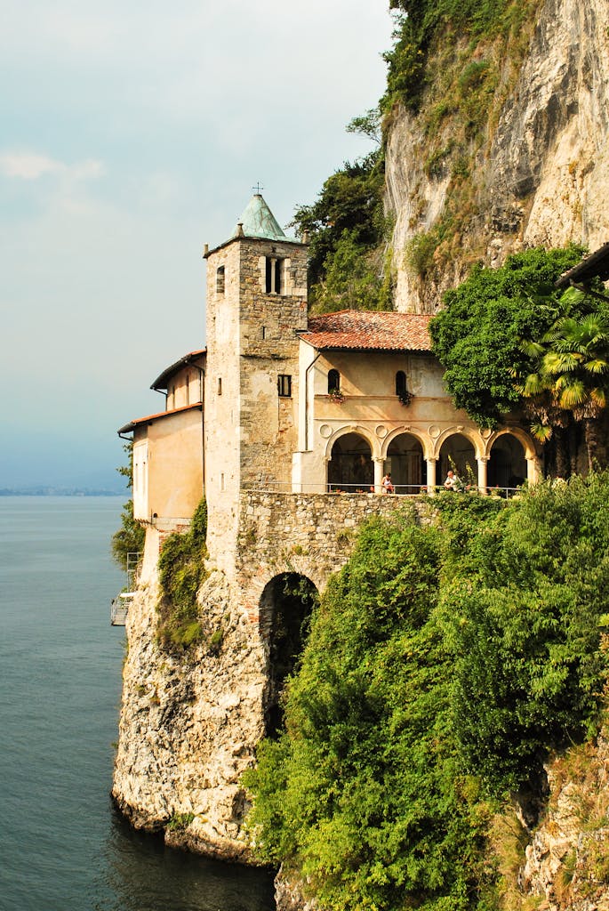 A picturesque monastery on a cliff overlooking the serene waters of Lake Maggiore in Stresa, Italy.