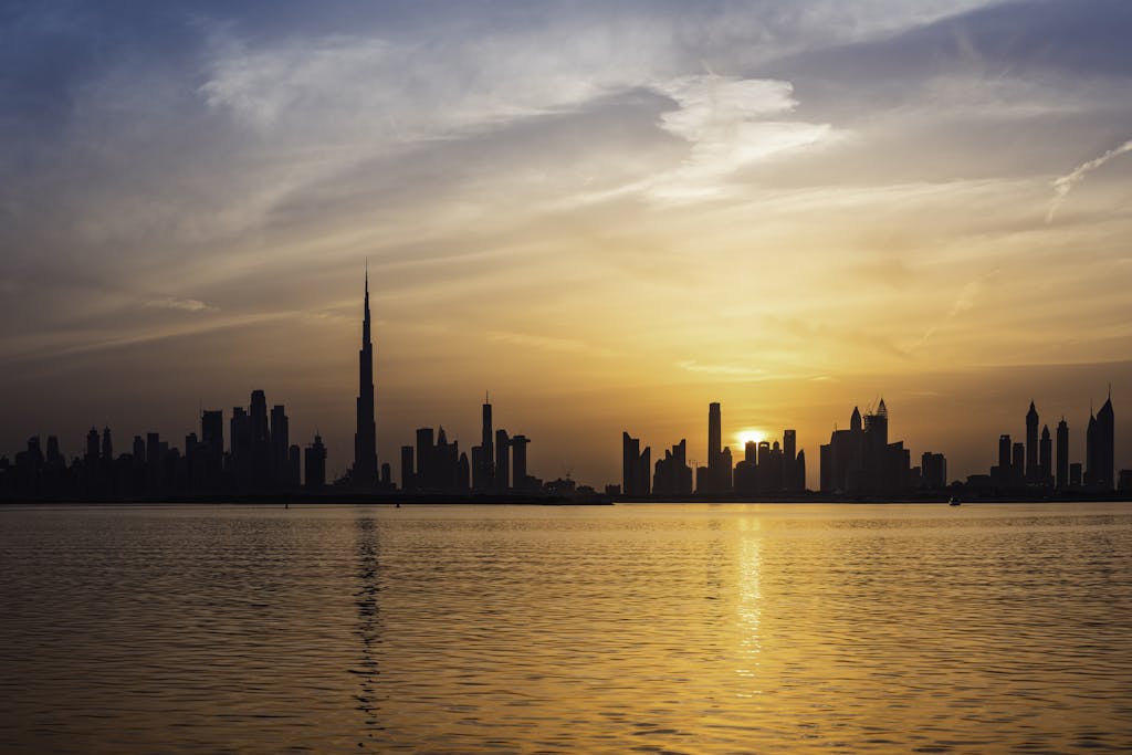 Enchanting view of Dubai's skyscrapers at sunset with the iconic Burj Khalifa outlined against the vivid sky.